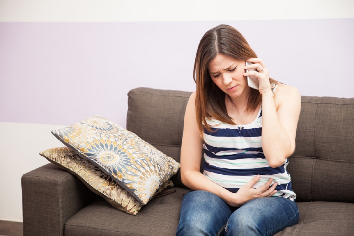 Боль в спине. Женщина с больным животом за компьютером. Тревога. Болит спина. Боль в голове.